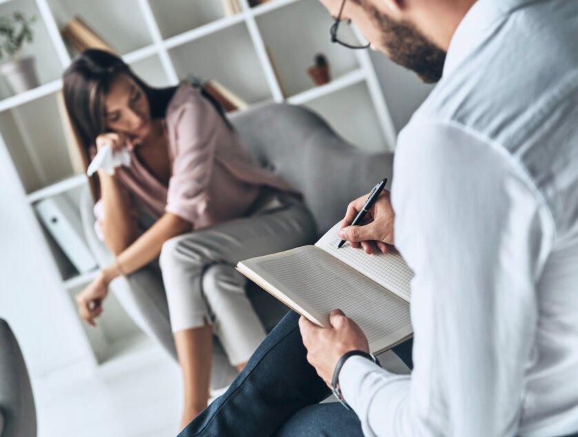 Tired of being unhappy. Young frustrated woman solving her mental problems while sitting on the therapy session with psychologist