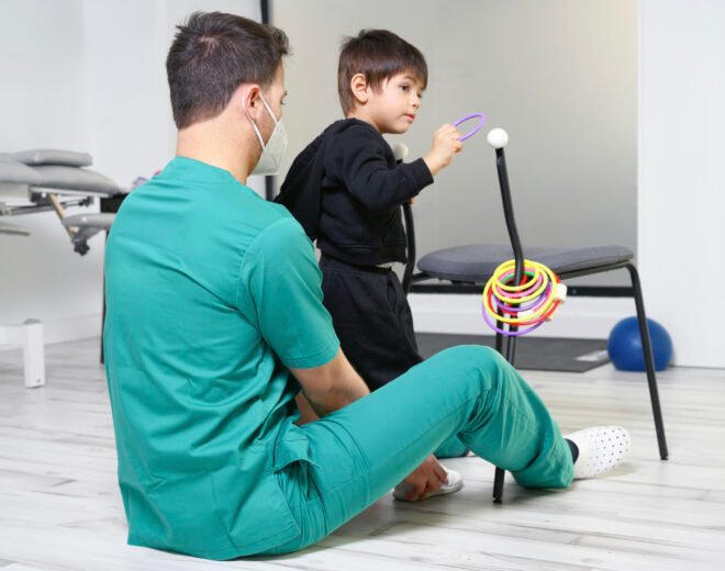 Child with cerebral palsy on physiotherapy in a children therapy center. Boy with disability doing exercises with physiotherapists in rehabitation centre. High quality photo.